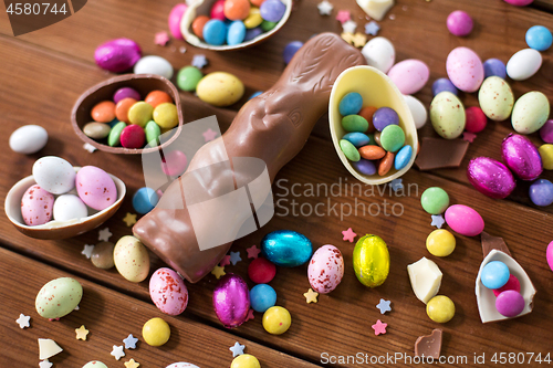 Image of chocolate eggs, easter bunny and candies on wood