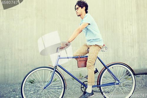 Image of young hipster man riding fixed gear bike