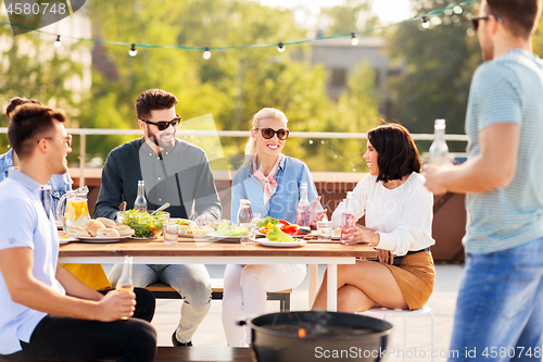 Image of happy friends having bbq party on rooftop