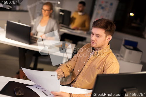 Image of designer or software developer at night office