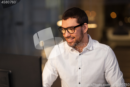 Image of businessman with computer working at night office