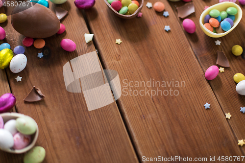 Image of chocolate eggs and candy drops on wooden table