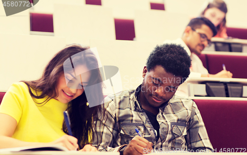 Image of group of students with notebooks in lecture hall