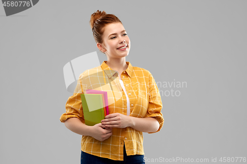 Image of smiling red haired teenage student girl with books