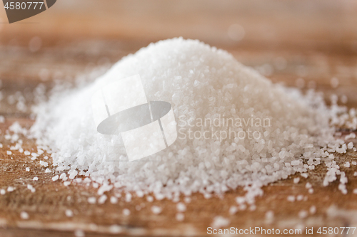 Image of close up of white salt heap on wooden table