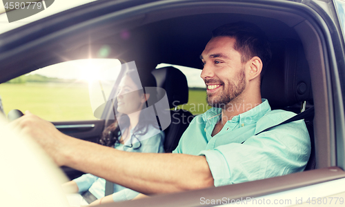 Image of happy man and woman driving in car