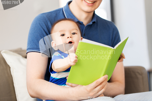 Image of happy father and little baby son with book at home