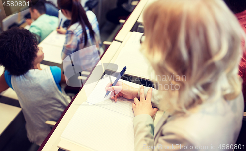 Image of student writing to notebook at exam or lecture