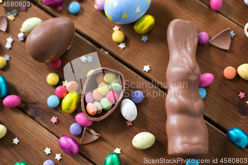 Image of chocolate eggs, easter bunny and candies on wood