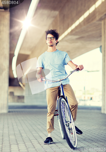 Image of young hipster man riding fixed gear bike