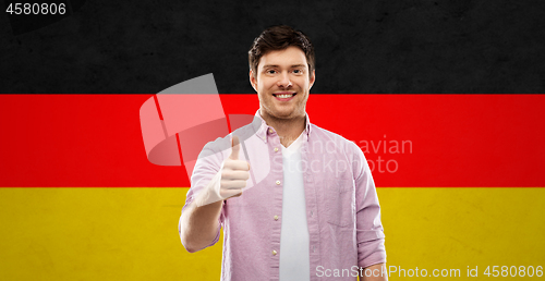 Image of happy man showing thumbs up over german flag