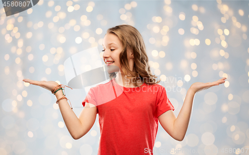 Image of smiling teenage girl holding empty hand