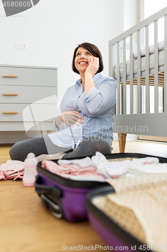 Image of pregnant woman packing hospital bag and calling