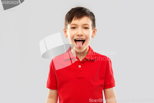 Image of boy in red polo t-shirt showing his tongue