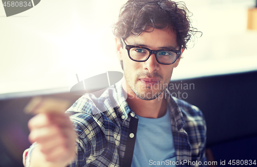 Image of happy man paying with credit card at cafe