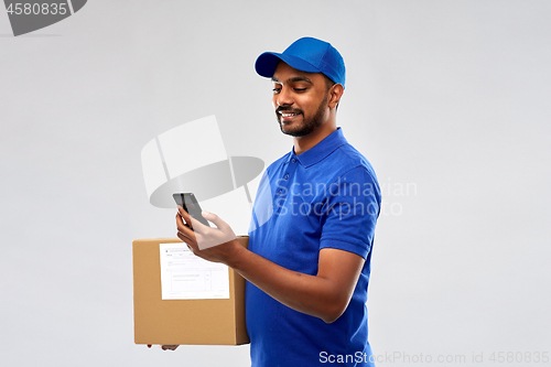 Image of indian delivery man with smartphone and parcel box