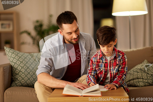 Image of father and son doing homework together