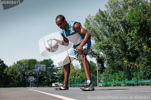 Image of Picture of young confused african basketball player practicing