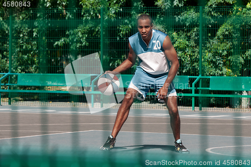 Image of Picture of young confused african basketball player practicing