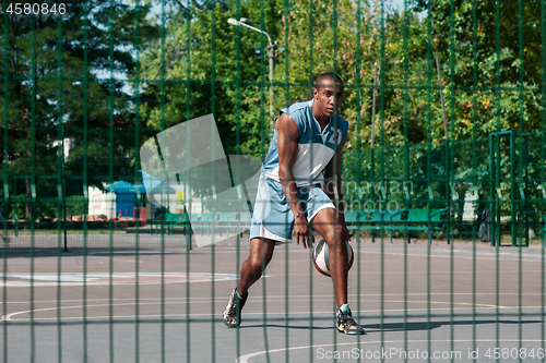 Image of Picture of young confused african basketball player practicing