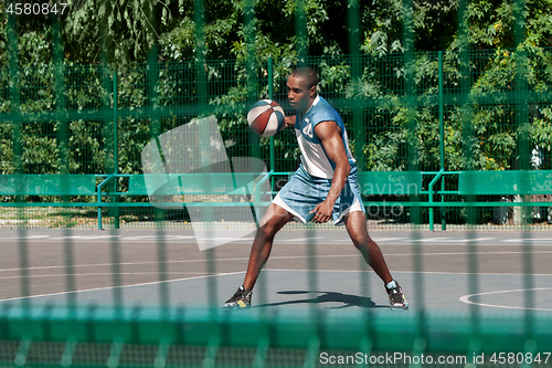 Image of Picture of young confused african basketball player practicing