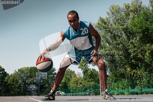 Image of Picture of young confused african basketball player practicing