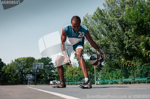 Image of Picture of young confused african basketball player practicing