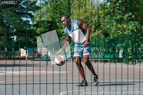Image of Picture of young confused african basketball player practicing