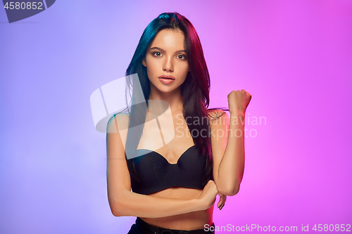 Image of High Fashion model woman in colorful bright lights posing in studio