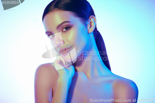 Image of High Fashion model woman in colorful bright lights posing in studio