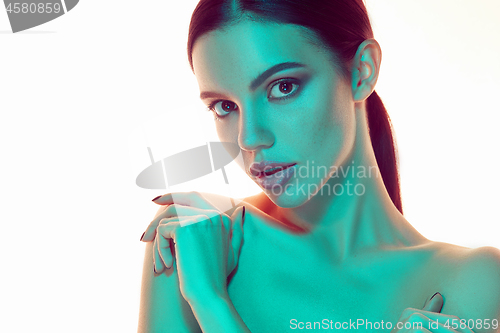 Image of High Fashion model woman in colorful bright lights posing in studio