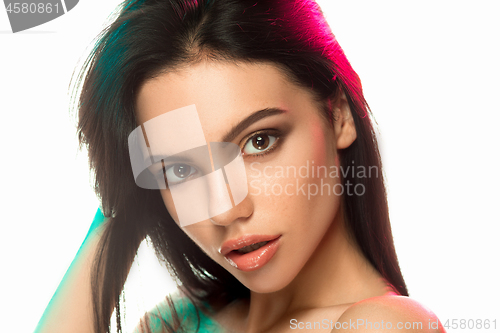 Image of High Fashion model woman in colorful bright lights posing in studio