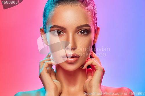 Image of High Fashion model woman in colorful bright lights posing in studio