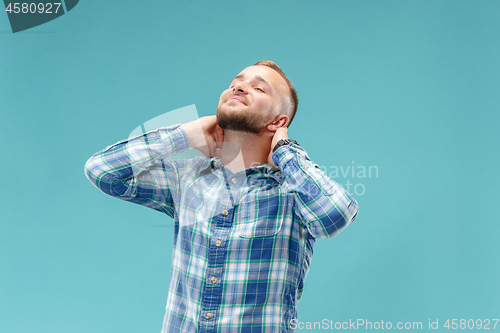 Image of The happy businessman standing and smiling against blue background.