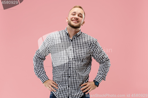 Image of The happy business man standing and smiling against pink background.