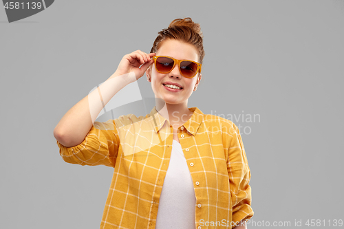 Image of smiling red haired teenage girl in sunglasses