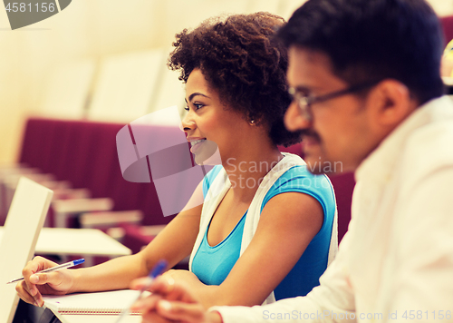 Image of group of students with notebooks in lecture hall