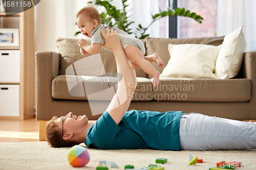 Image of happy father with little baby son playing at home