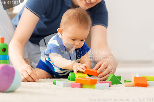 Image of baby boy with father playing toy blocks at home