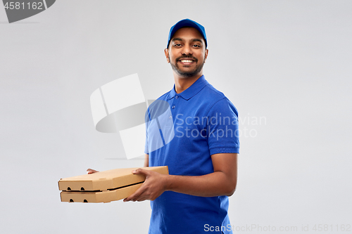 Image of happy indian delivery man with pizza boxes in blue