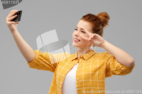 Image of redhead teenage girl taking selfie by smartphone