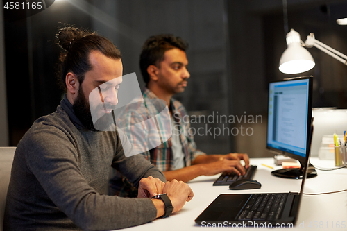 Image of creative man with smartwatch working at office