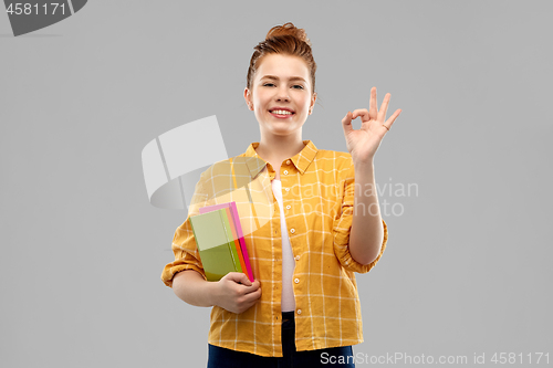 Image of redhead teenage student girl with books showing ok