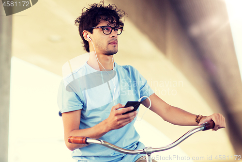 Image of man with smartphone and earphones on bicycle