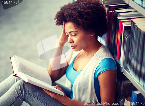 Image of african student girl reading book at library