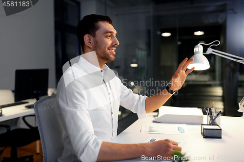 Image of businessman using gestures at night office