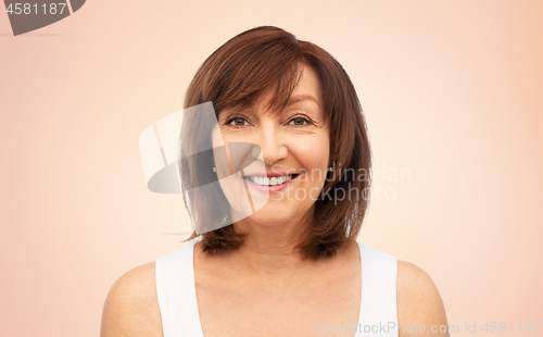 Image of portrait of smiling senior woman over beige