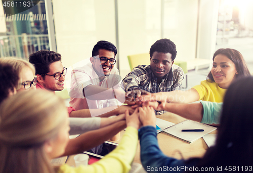 Image of group of international students with hands on top