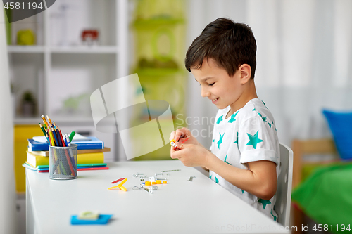 Image of little boy playing with building kit at home