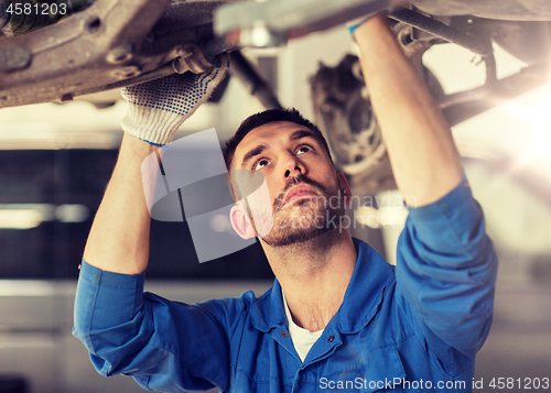 Image of mechanic man or smith repairing car at workshop